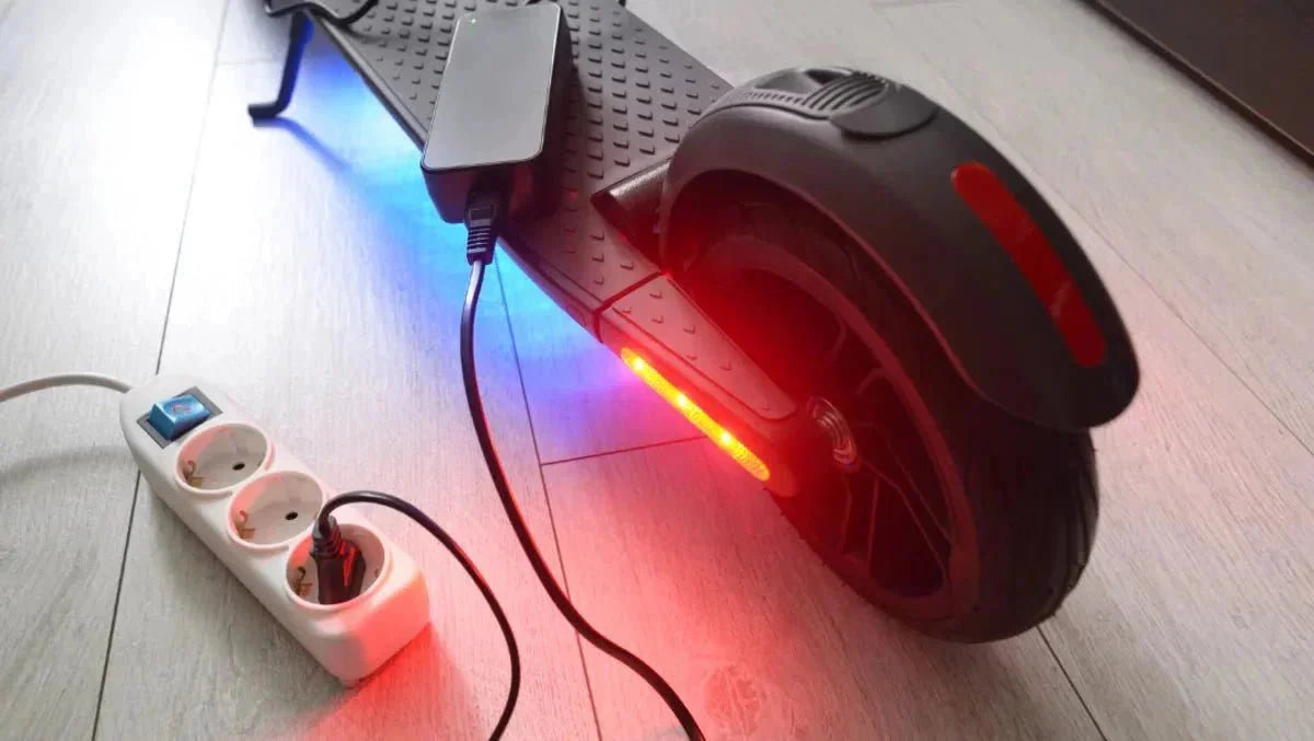 E-Scooter lädt in der Wohnung, das Ladegerät steckt in einer Steckdosenleiste – E-Scooter-Reichweite erhöhen