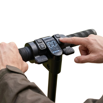 Nahaufnahme des Lenkers mit Display und Tasten, ein Finger drückt eine Taste