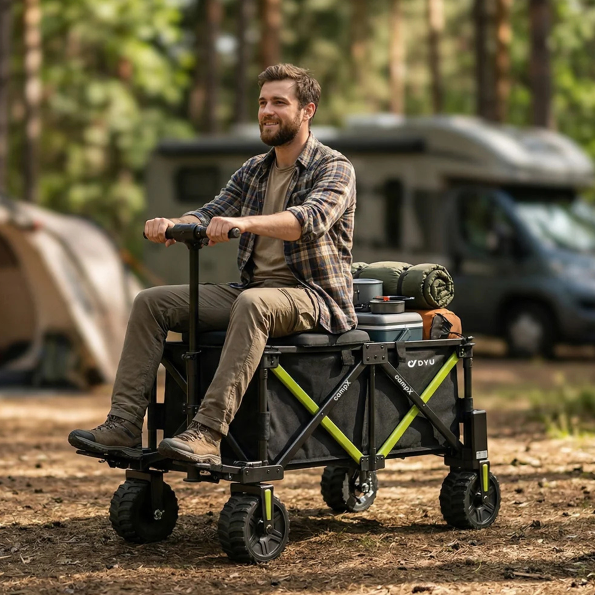 Ein Mann sitzt auf dem DYU CampX mit Gepäck auf einem Campingplatz im Wald, Wohnmobil und Zelt im Hintergrund