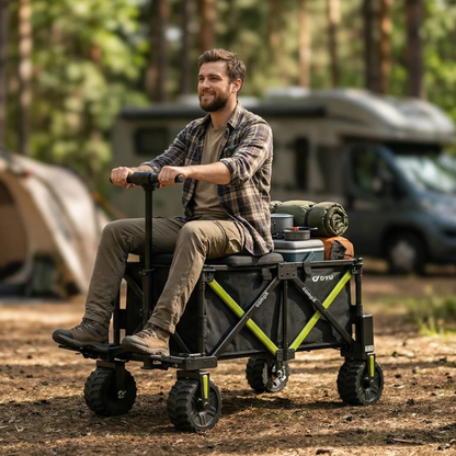 Ein Mann sitzt auf dem DYU CampX mit Gepäck auf einem Campingplatz im Wald, Wohnmobil und Zelt im Hintergrund