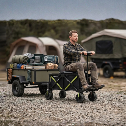 DYU CampX auf Schotter, ein Mann sitzt auf dem Wagen neben einem beladenen Anhänger und einem Zelt