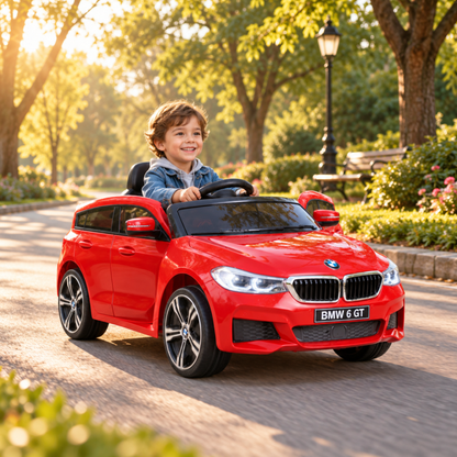 Kind fährt das BMW 6GT Elektroauto für Kinder in einem Park