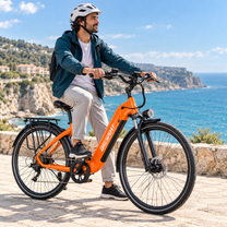 Mann sitzt auf einem orangefarbenen OneSport OT05 Max am Meer, im Hintergrund Felsen