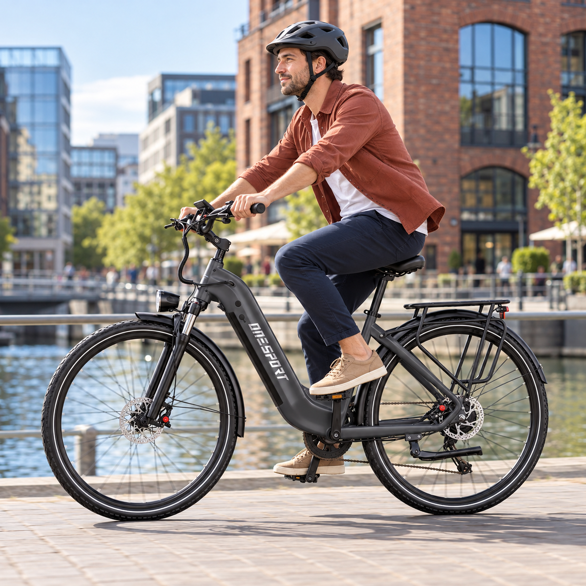 Mann mit Helm fährt ein dunkelgraues OneSport OT05 Max an einer Kaimauer am Wasser entlang