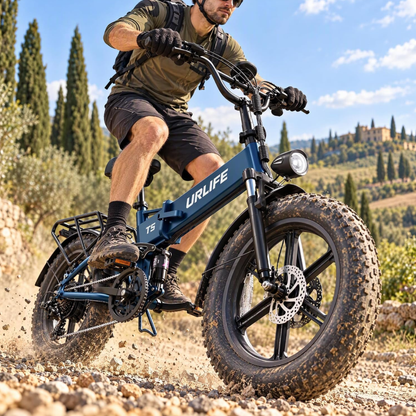 Blaues URLIFE T5 E-Bike mit dicken Reifen, das ein Mann auf einem Schotterweg fährt