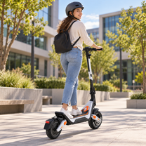 Wheely - J18 E-Scooter von hinten mit Fahrer in Helm und mit Rucksack zwischen Bäumen und Gebäuden