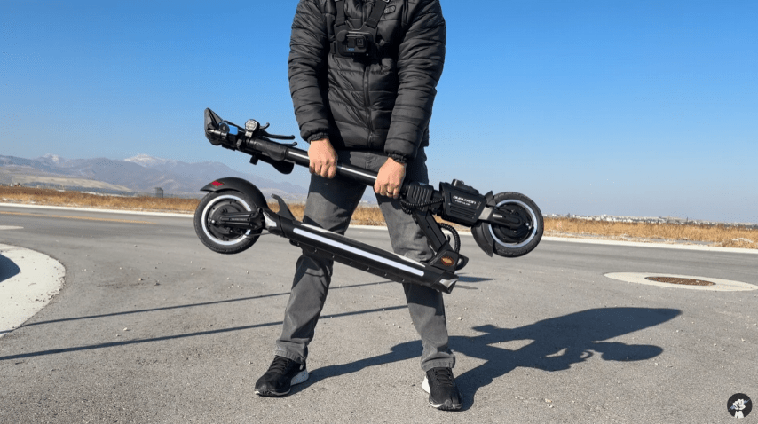 Person trägt den zusammengeklappten DUALTRON POPULAR E-Scooter