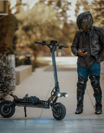 Mann steht neben dem DUALTRON THUNDER 3 E-Scooter auf einem Fußweg