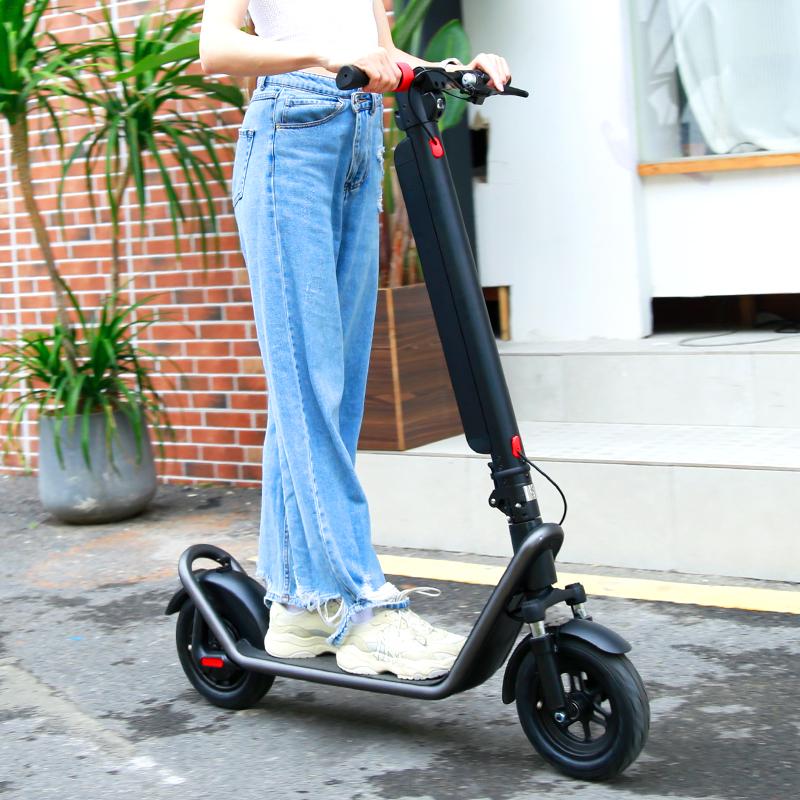 Frau steht neben dem HX X11 E-Scooter auf einer Straße