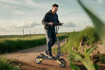 Mann auf dem iENYRID ES1 E-Scooter auf einer Wiese