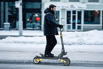 Mann auf dem iENYRID ES1 E-Scooter im Schnee
