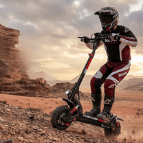 Person steht neben dem iScooter GX3 Pro E-Scooter auf sandigem Untergrund