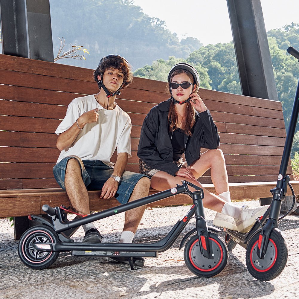 Person sitzt neben dem iScooter i9M E-Scooter