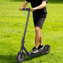 Mann auf dem SEEDREAM RED WING MINI E-Scooter auf einer Wiese