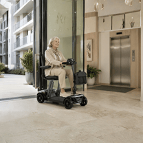 Ältere Frau sitzt auf dem Sweetrich Air Traveller Elektromobil drinnen