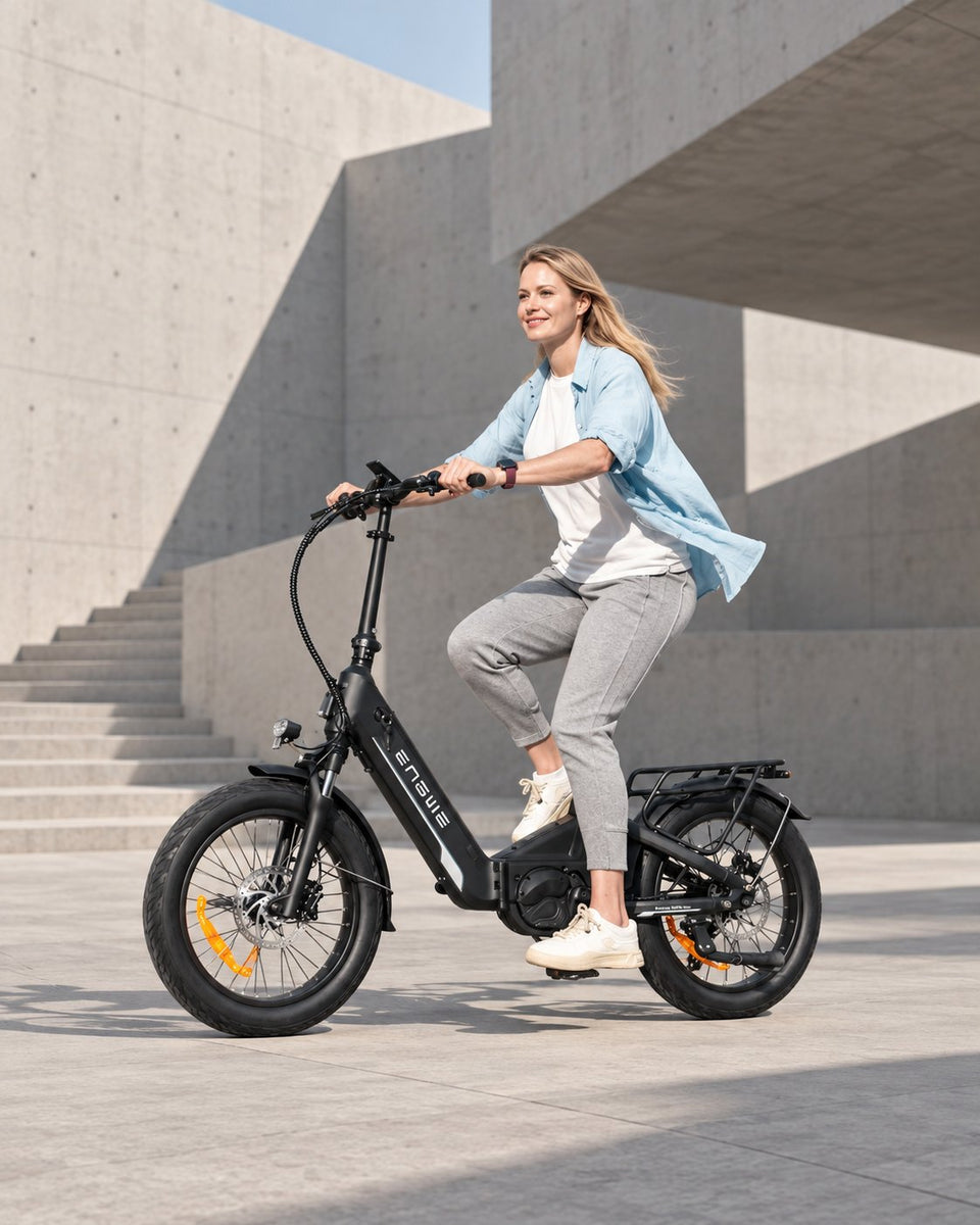 E-Bike von Wheelyshop – Fahrerin auf einem faltbaren ENGWE E-Bike vor moderner Betonarchitektur