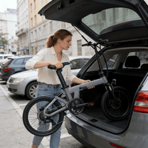 Frau steht neben dem YANGOR H19 faltbaren E-Bike in Grau